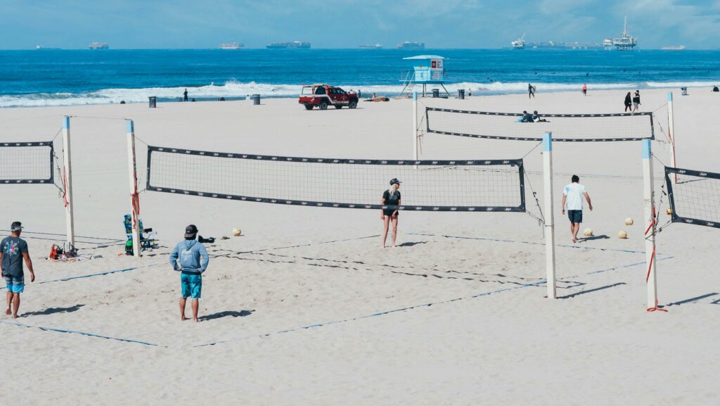A fun beach volleyball game with players on a sunny day by the ocean.