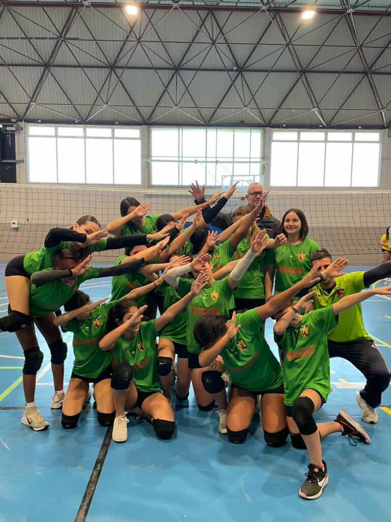 Jugadoras del Club Voleibol Ifach celebrando en grupo en pista cubierta de voleibol