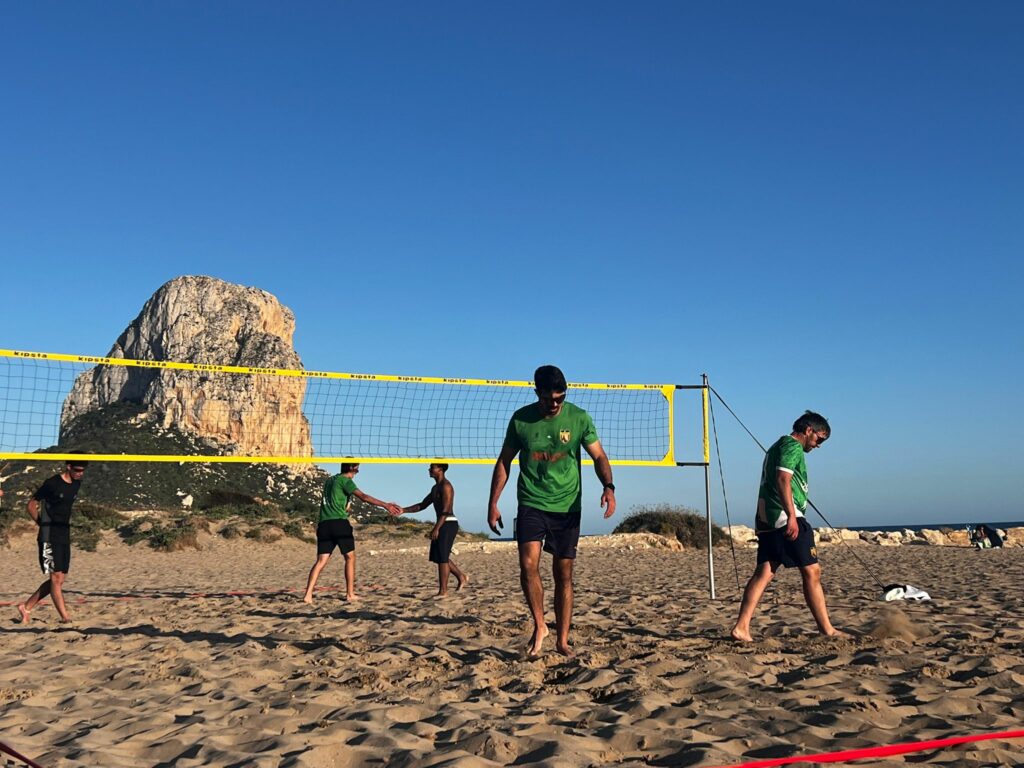Jugadores del Club Voleibol Ifach y Club Voley Playa Las Rozas durante un partido de vóley playa en la playa con el Peñón de Ifach al fondo