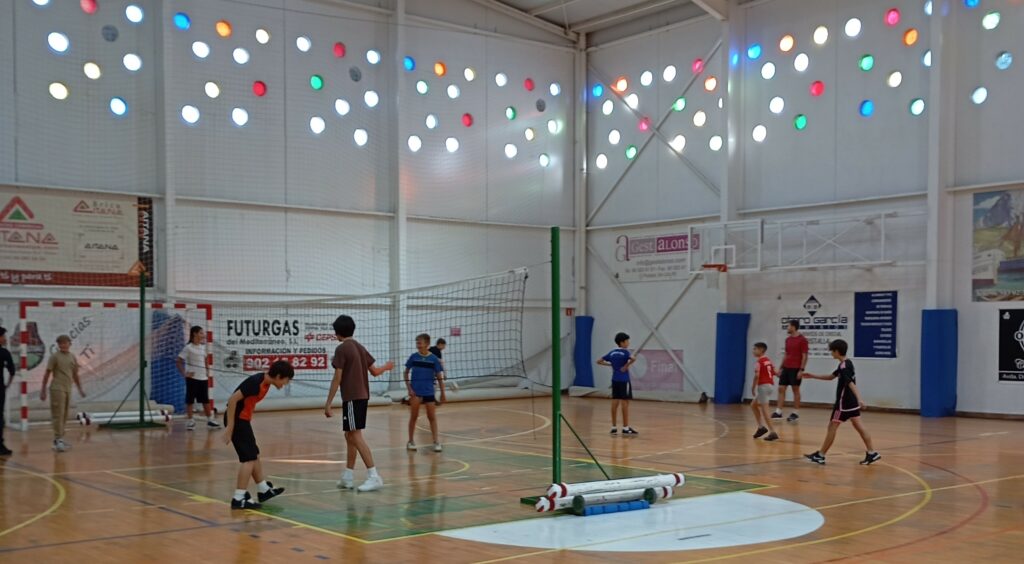 Entrenadores del CV Ifach impartiendo voleibol en un pabellón a estudiantes de secundaria en Calpe