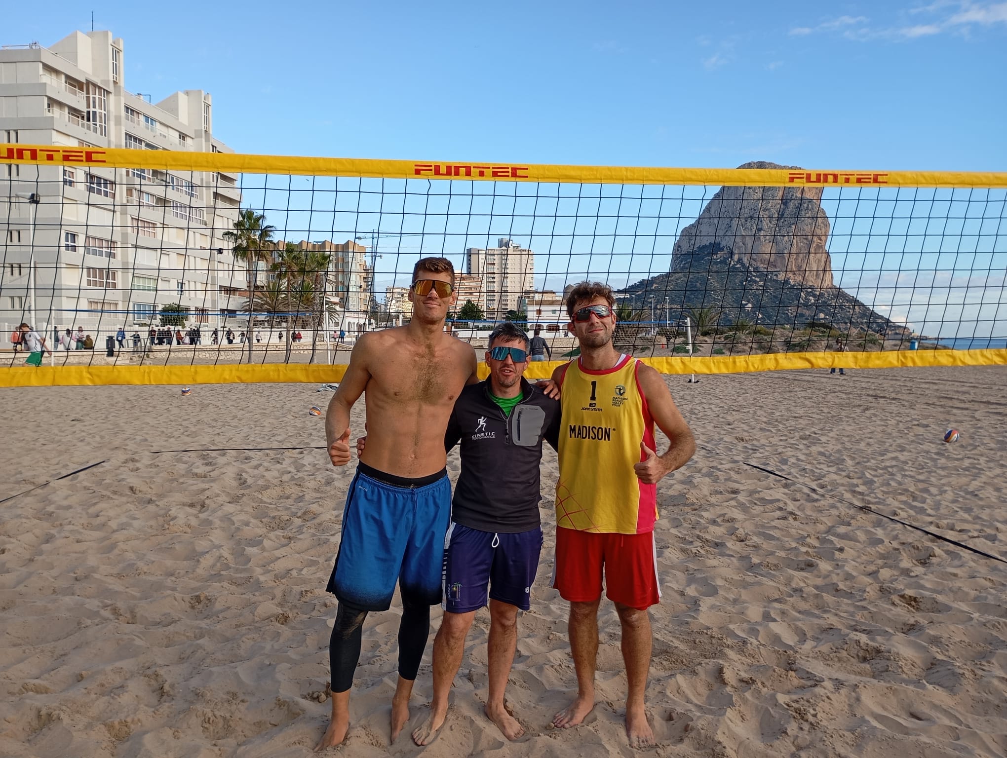 Pablo Pérez Suárez y Raúl Trujillo posan junto a otro jugador de vóley playa en la playa de la Montanyeta de Calpe, con el Peñón de Ifach al fondo