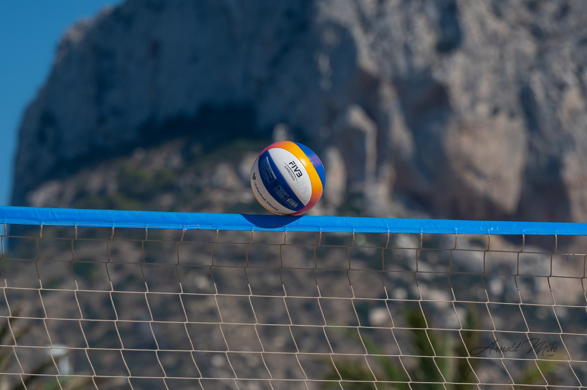 Balón de vóley playa sobre la red con el Peñón de Ifach al fondo en el Torneo Villa de Calp